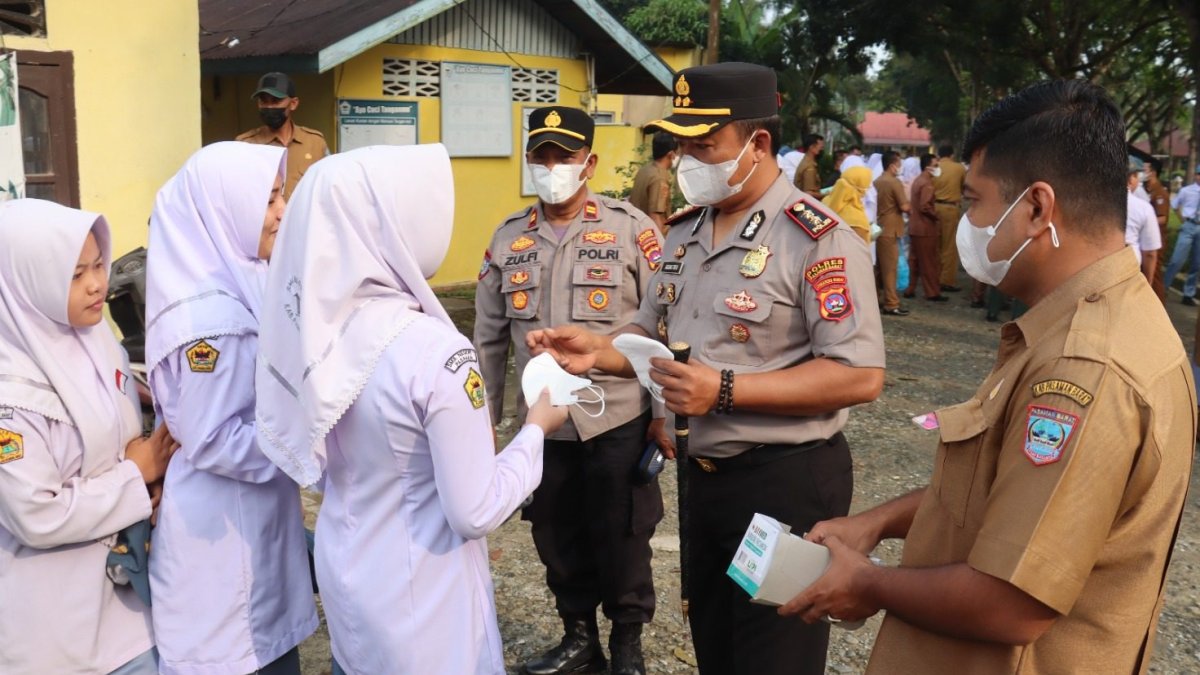 Kapolres Pasaman Barat membagikan masker medis kepada pelajar dan guru di SMAN 1 Pasaman untuk antisipasi dampak kabut asap.